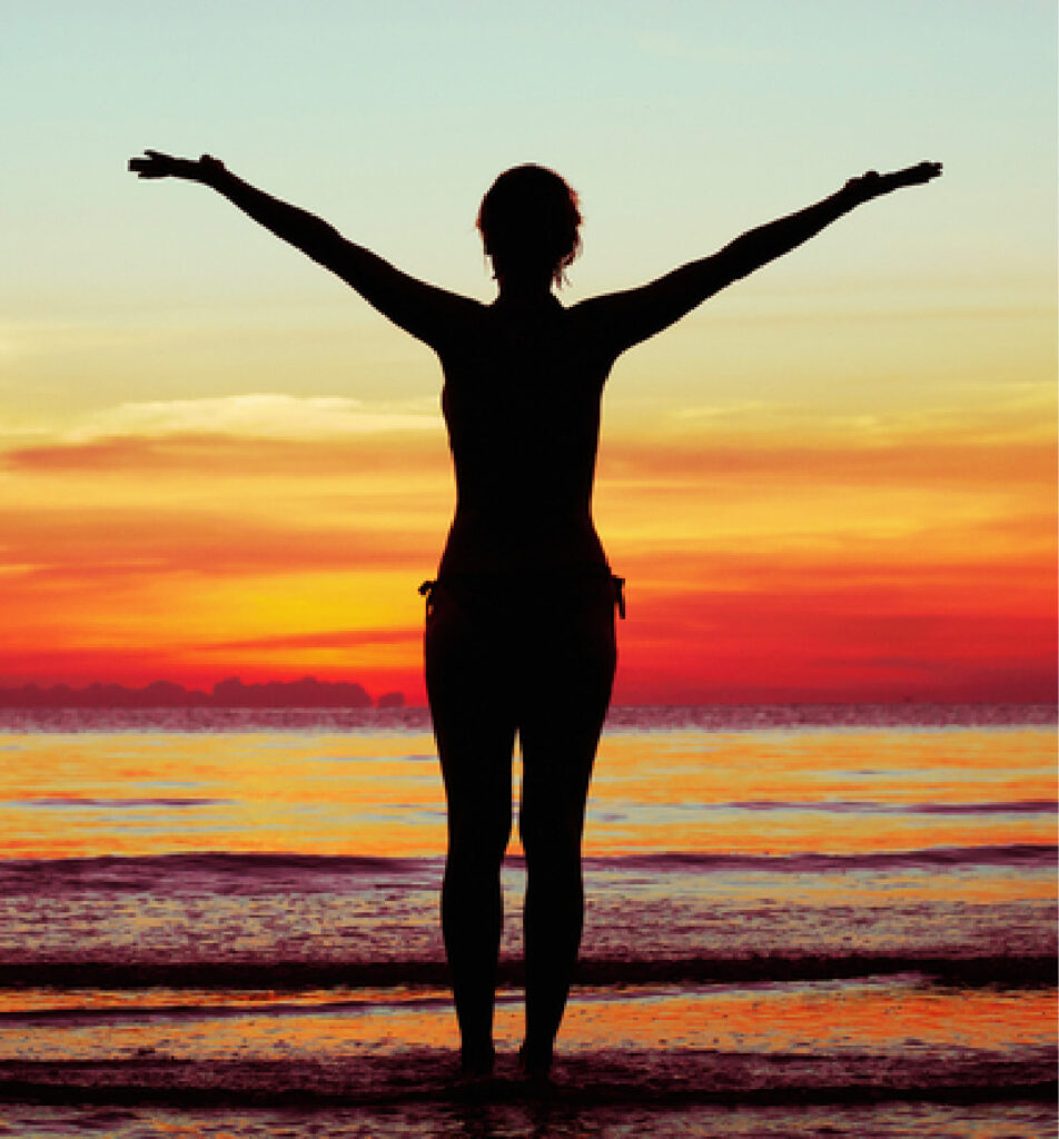 Silhouette of person enjoying sunset on the beach.